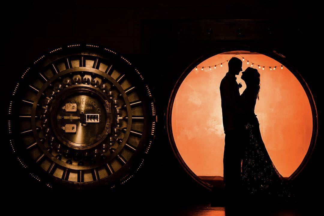 a silhouette of a wedding couple standing looking at each other