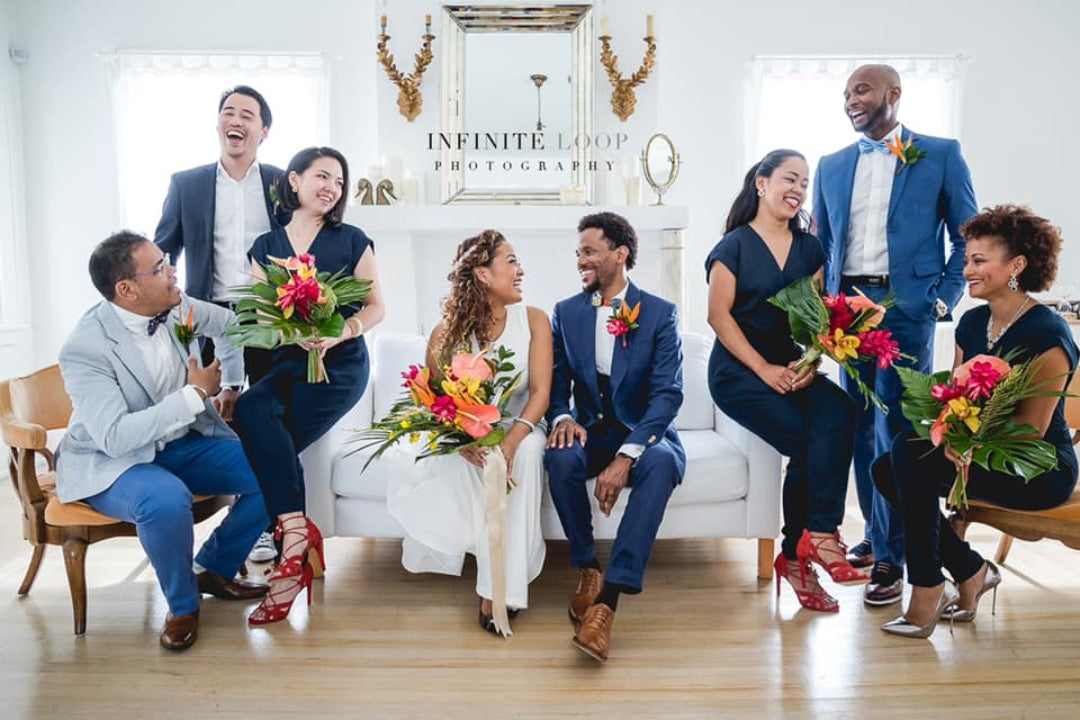 Bride and groom posing with the groomsmen and bridesmaids holding bouquets