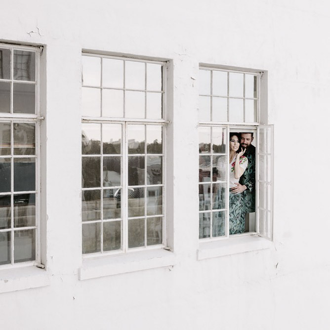 a couple looking out through the window reflections in wedding photography