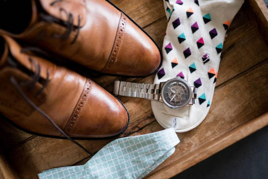 close up of shoes, watch, socks and bowtie on wedding day