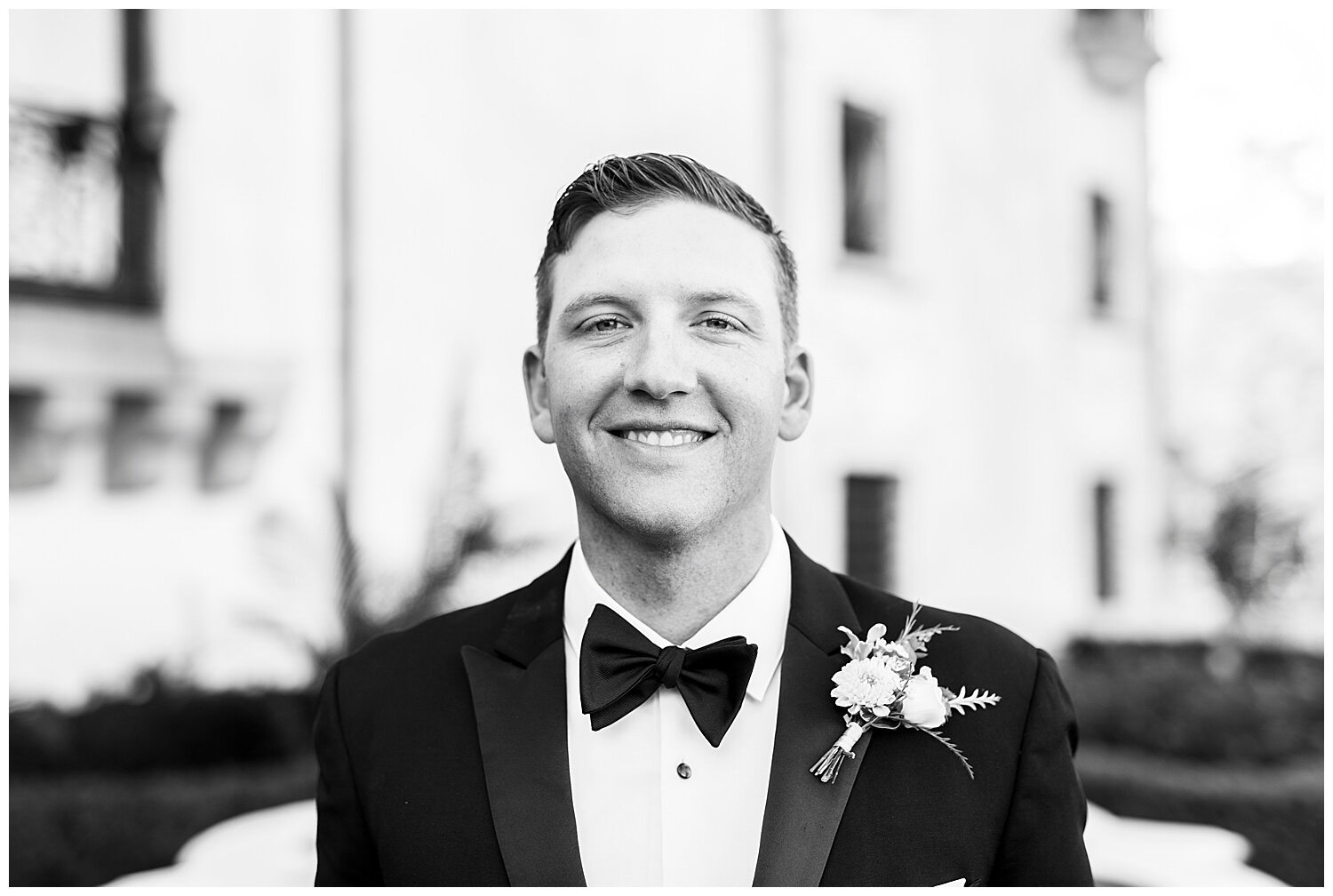 a portrait of a groom looking at the camera in his wedding suit