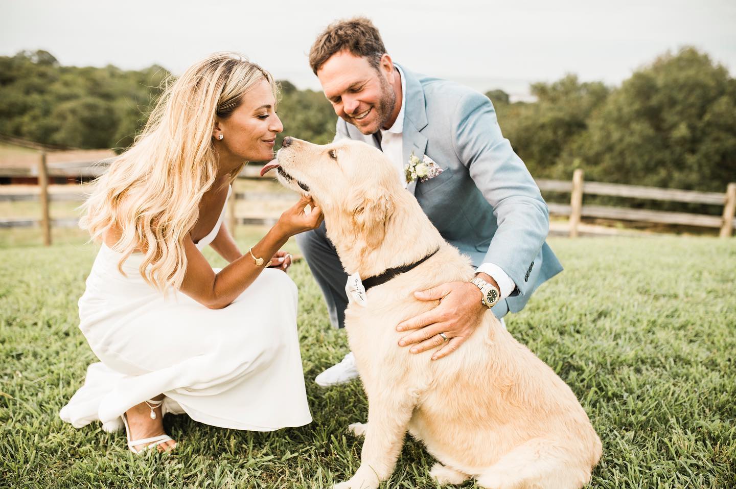 a wedding couple petting their pet dog