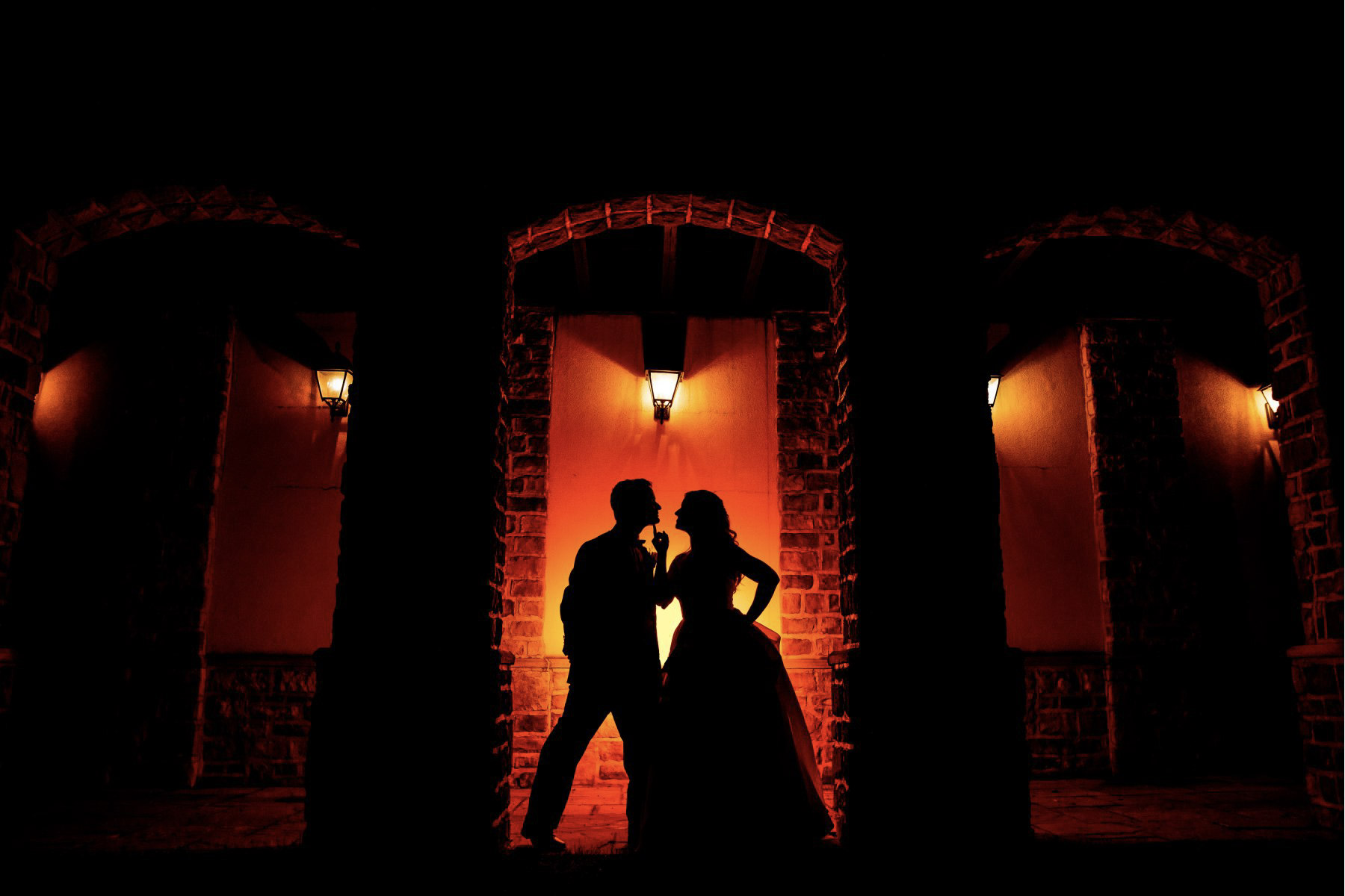 a silhouette image of a bride and the groom posing 